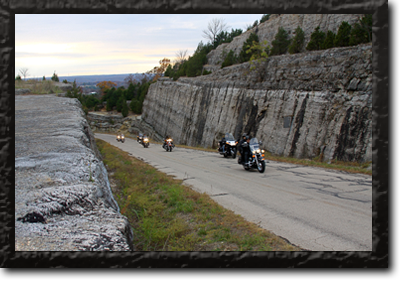 Seven bikers riding up a hilly road